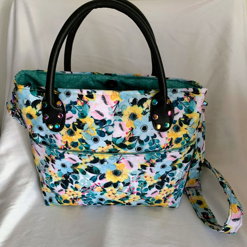 Designer vinyl tote with grab handles and adjustable crossbody