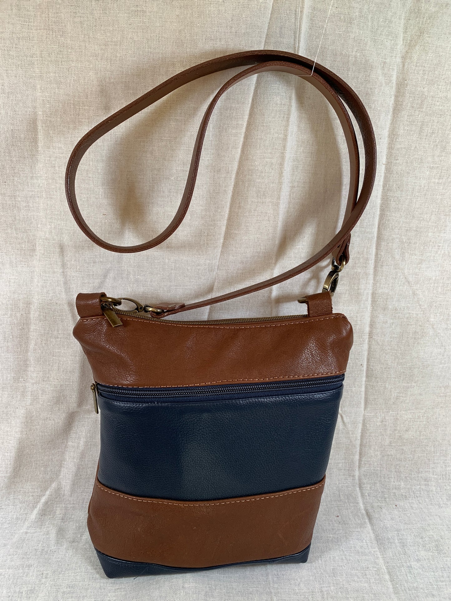 Cognac and navy blue classic striped all leather crossbody.