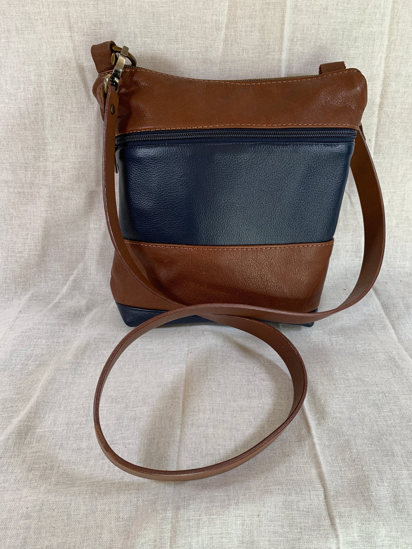 Cognac and navy blue classic striped all leather crossbody.