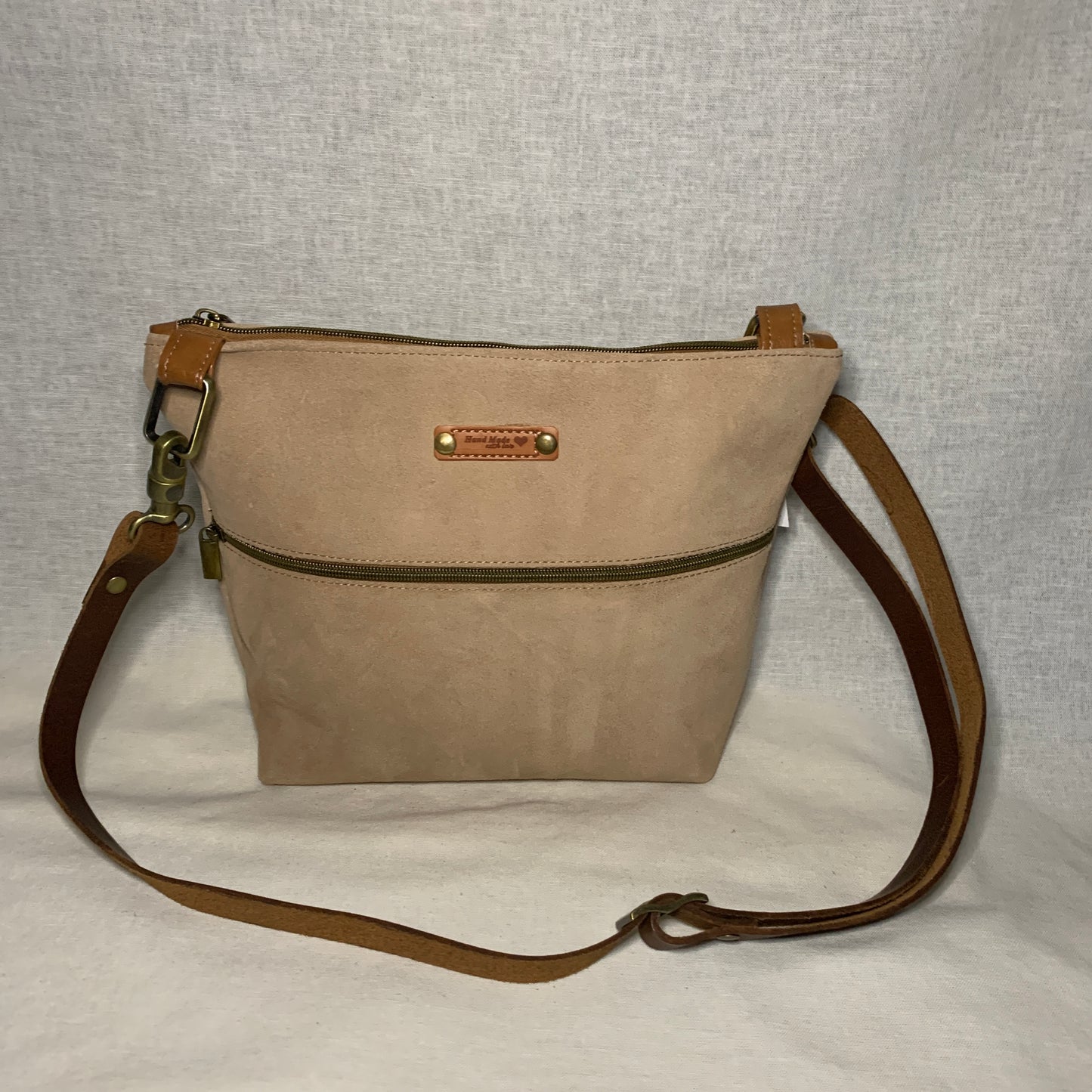 All leather crossbody buckskin bag with antique gold hardware and designer lining.