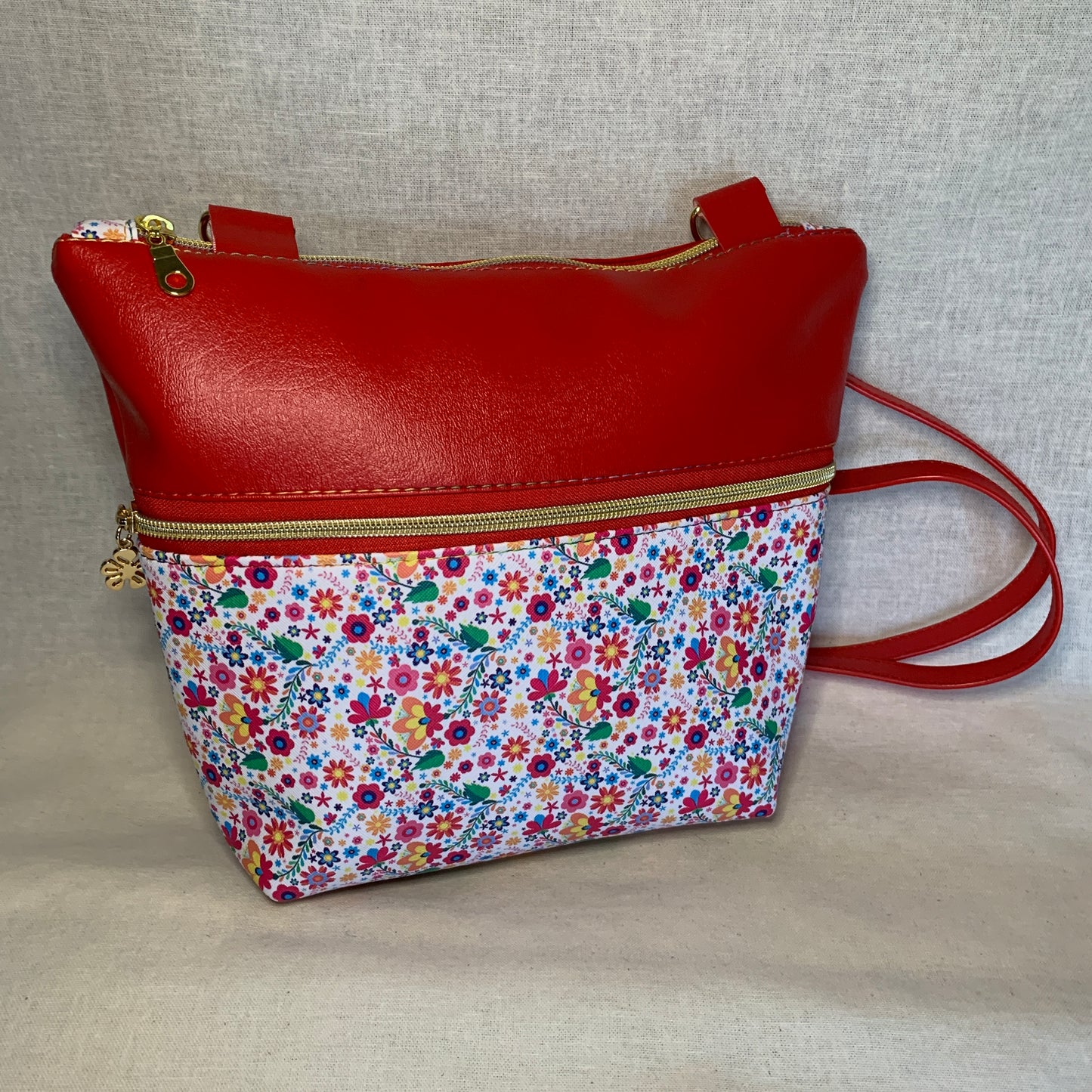 Colorful vinyl crossbody with two large exterior zipper pockets.