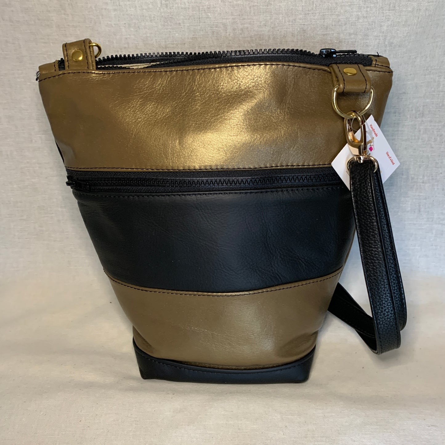 Beautiful black and gold all leather bag with adjustable crossbody strap.