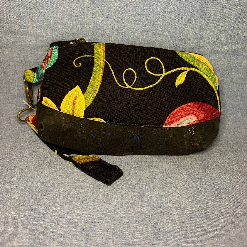 Home décor fabric brightens the black background of this wristlet.