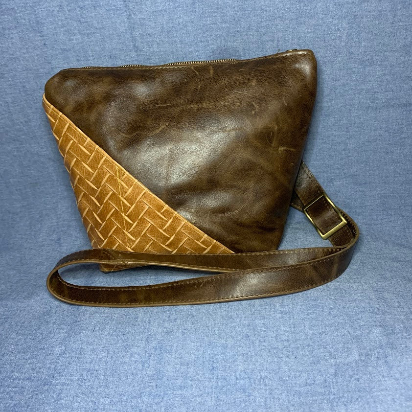 Enhanced by a slash pocket of woven leather, this Crazyhorse- like leather bag will charm you.