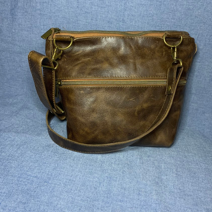 Enhanced by a slash pocket of woven leather, this Crazyhorse- like leather bag will charm you.
