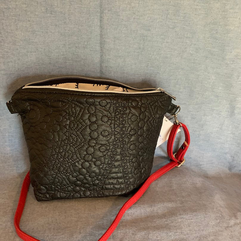 Black vinyl mini crossbody with contemporary lining and adjustable strap