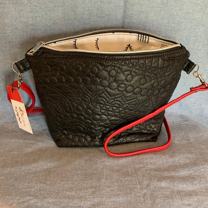 Black vinyl mini crossbody with contemporary lining and adjustable strap