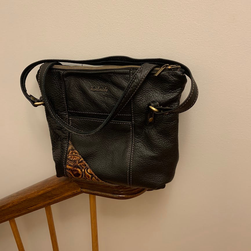 Black leather tote with two external slip pockets and fashion rivets to detail pocket