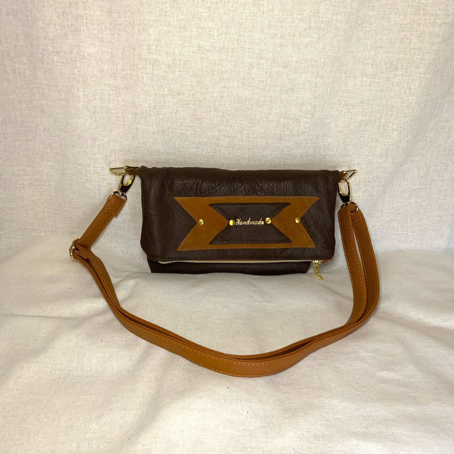 All leather small fold over crossbody bag with two external pockets and interior zip pockett.