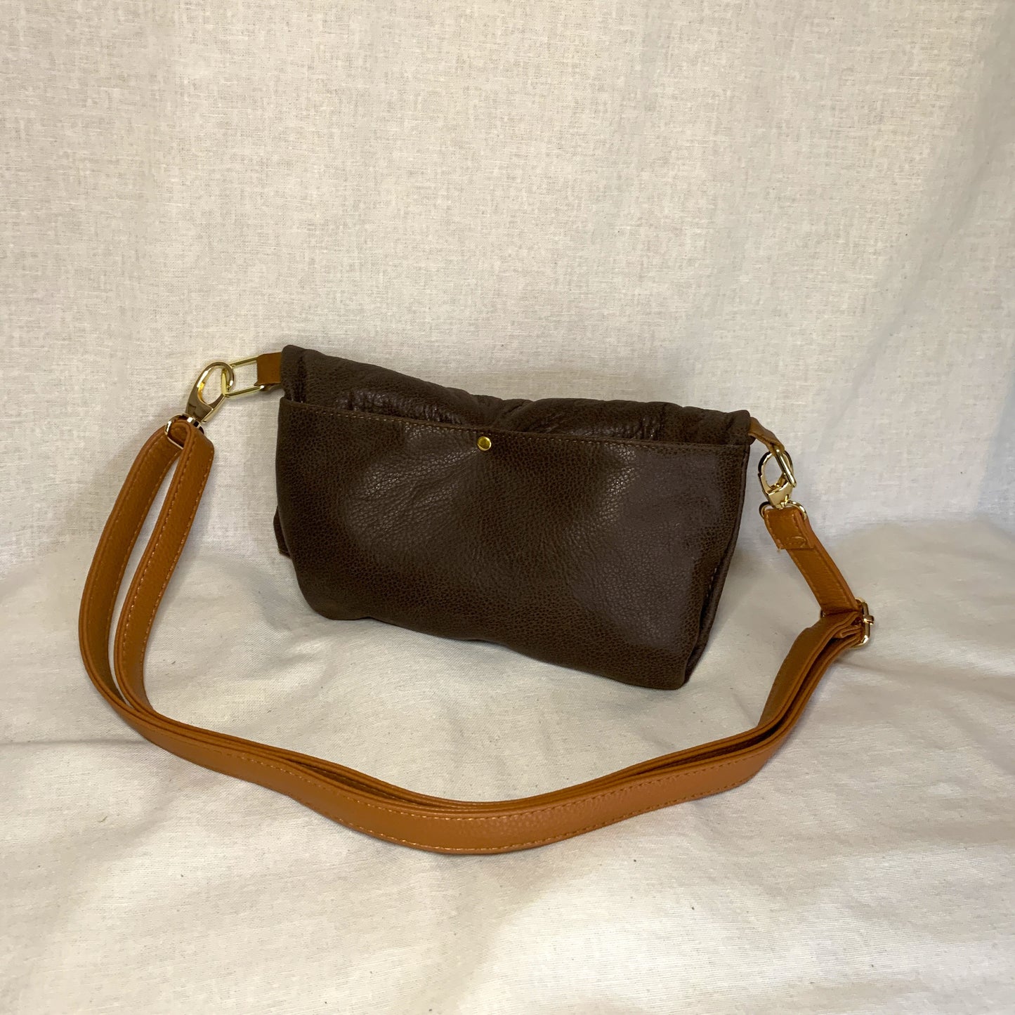 All leather small fold over crossbody bag with two external pockets and interior zip pockett.