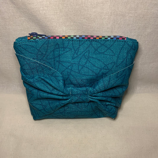 Vinyl pouch with bow front in attractive teal color with a distinctive zipper.